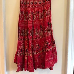 Red wrap skirt with pattern of peacocks, figures, and elephants